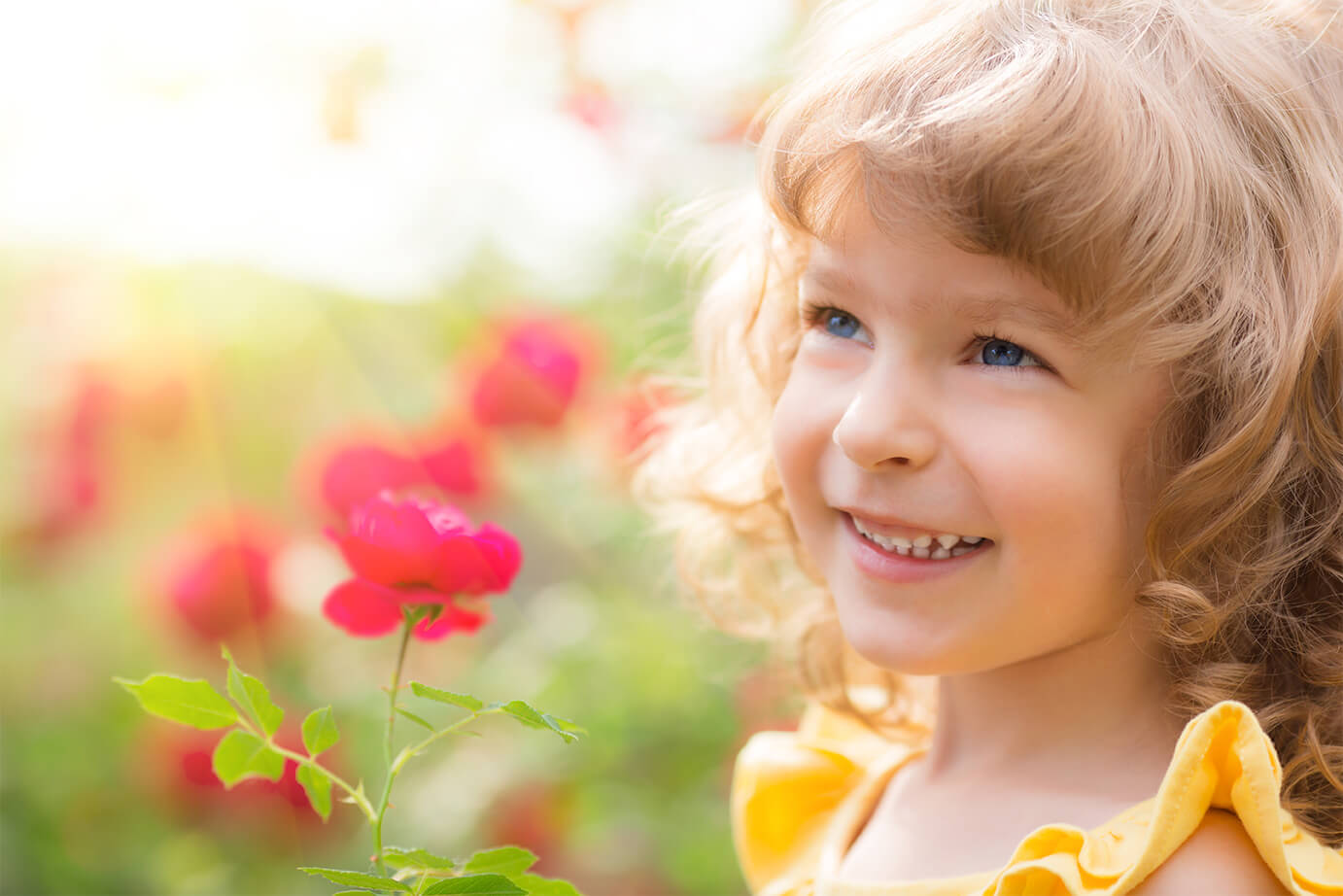 usmiechnięta dziewczynka wśród różowych kwiatów